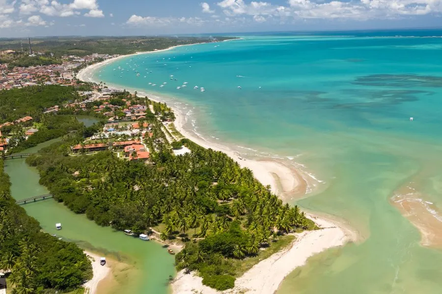 Vista panorâmica da estrutura do Salinas Maragogi All Inclusive Resort, com piscinas, jardins tropicais e área de lazer à beira-mar, em um dia ensolarado.
