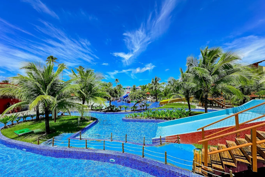 Piscinas com toboáguas e palmeiras em resort tropical